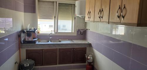 eine Küche mit einem Waschbecken und einem Fenster in der Unterkunft appartement meublé avec wifi in Safi