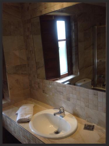 a bathroom with a sink and a mirror at Hotel La Rad in Galindo y Perahuy