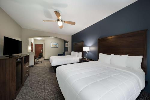 a hotel room with two beds and a flat screen tv at Best Western Plus Lake Dallas Inn & Suites in Lake Dallas