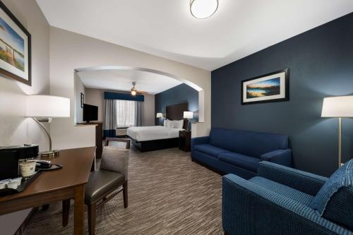 Habitación de hotel con sofá y cama en Best Western Plus Lake Dallas Inn & Suites, en Lake Dallas
