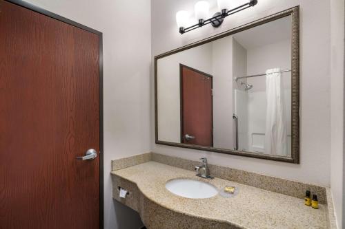a bathroom with a sink and a large mirror at Best Western Plus Lake Dallas Inn & Suites in Lake Dallas