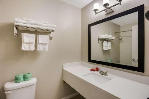 een badkamer met een wastafel en een spiegel bij SureStay Hotel by Best Western Higginsville in Higginsville