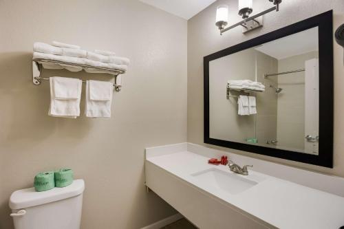 a bathroom with a sink and a mirror at SureStay Hotel by Best Western Higginsville in Higginsville