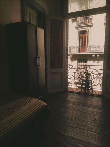 un dormitorio con ventana y una persona sentada en un banco en Residencia estudiantes Recoleta en Buenos Aires