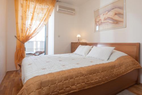 een slaapkamer met een groot bed en een raam bij Apartments Kalalarga Deluxe- city centre&balcony in Makarska