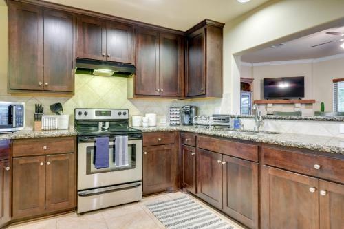 a kitchen with wooden cabinets and a stove at New Braunfels Home with Pool 2 Mi to Guadalupe River in New Braunfels