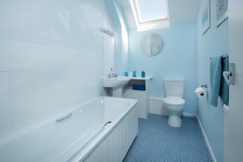 a white bathroom with a sink and a toilet at Coldstream Coach House in Coldstream