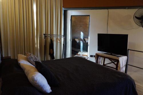 Schlafzimmer mit einem Bett und einem Flachbild-TV in der Unterkunft Loft Lomas Del Suquia in Cordoba