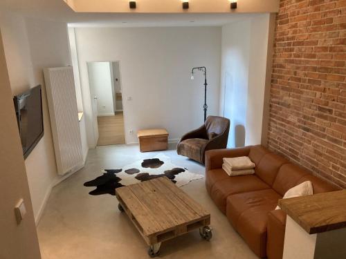 ein Wohnzimmer mit einem Sofa und einem Tisch in der Unterkunft SUITE-DREAMS LOFT - Innenstadt in Hannover