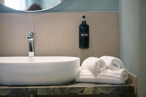 a bathroom with a sink and towels on a counter at Rooms Don Alfonso in Parma