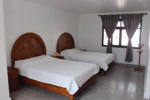 a bedroom with two beds and a window at Casa Tenorio Hospedaje in Orizaba