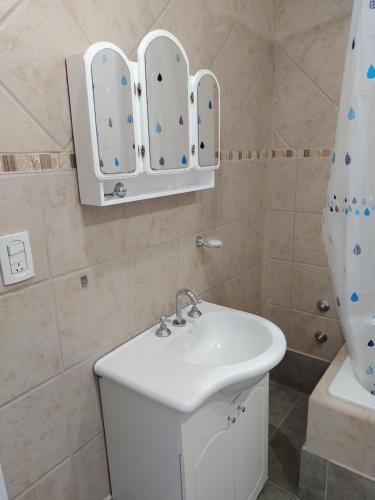 ein Badezimmer mit einem weißen Waschbecken und einer Dusche in der Unterkunft Duplex Escritores Argentinos in Rawson
