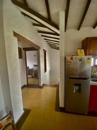 a kitchen with a refrigerator in the middle of a room at Hospedaje Iraca - Pueblito Boyacense Duitama in Duitama