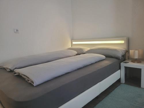 ein Bett mit zwei Kissen auf einem Zimmer in der Unterkunft Stilvolle Wohnung in Wuppertal inkl. Kaffee & Tee in Wuppertal