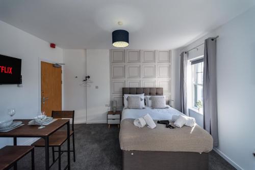 1 dormitorio con cama, mesa y escritorio en Croft Road Apartments, en Neath