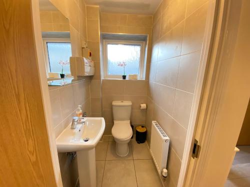 a small bathroom with a toilet and a sink at Burton - 4 Bedroom Detached Home in Shenley Church End