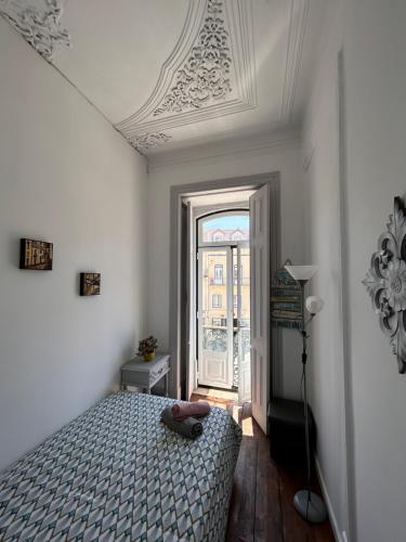 a bedroom with a bed and a window at Hostel Sun River in Almada