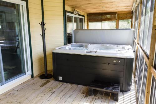 a bath tub sitting inside of a house at Chalet aux mille étoiles near Mt-Tremblant with Hot Tub in La Conception