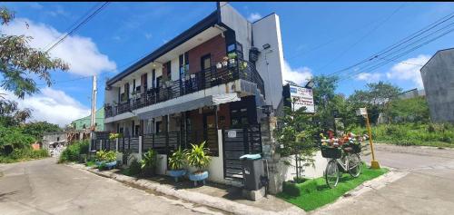un bâtiment avec un balcon et des plantes dans une rue dans l'établissement Lucena Meg's Studio Apmnt VIP rm-Near SM-Wifi, à Ilayang Dupay