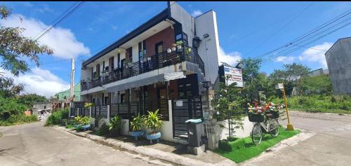 a building with a balcony and plants on a street at Lucena Meg's Studio Apmnt VIP rm-Near SM-Wifi in Ilayang Dupay