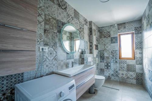 a bathroom with a sink and a toilet and a mirror at Villa Modriola heated Pool in Donji Proložac