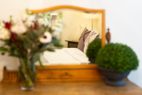 a bedroom with a bed with a mirror and flowers at The Edward Townhouses 151 - 157 in Orange