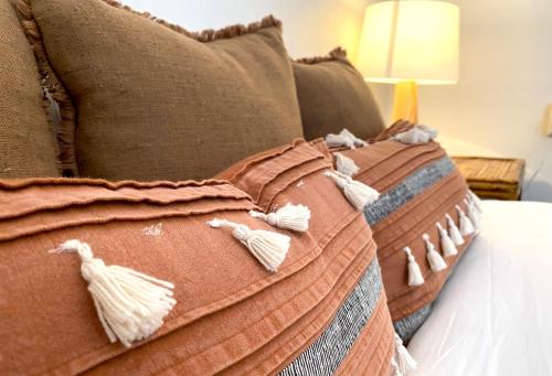 a bed with some pillows on top of it at The Edward Townhouses 151 - 157 in Orange