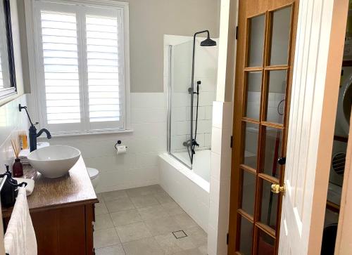 a bathroom with a tub and a sink and a shower at The Edward Townhouses 151 - 157 in Orange