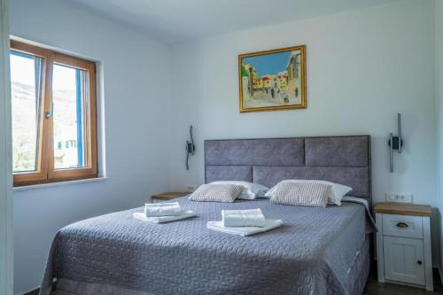 a bedroom with a bed with two towels on it at Villa Modriola heated Pool in Donji Proložac