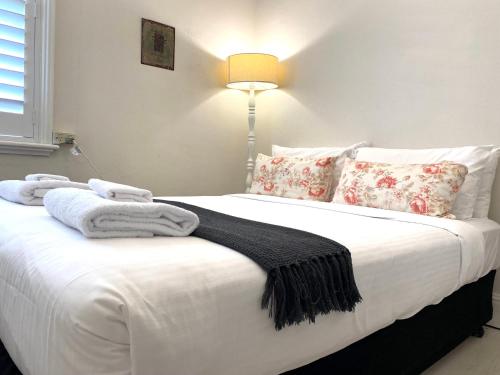 a bedroom with a white bed with towels on it at The Edward Townhouses 151 - 157 in Orange
