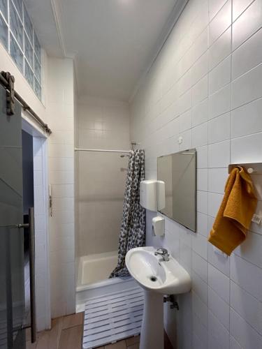 a bathroom with a sink and a shower at Hostel Sun River in Almada