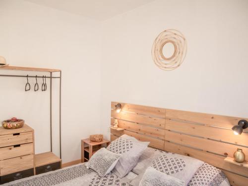 een slaapkamer met een bed met een houten hoofdeinde en kussens bij Loustalet Plus in Bagnols-en-Forêt