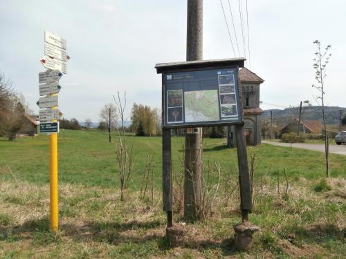 a sign in the grass next to a street at Apartmány Na Rozcestí in Lomnice nad Popelkou