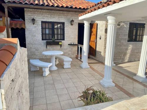 a patio with white columns and a bench on a house at 3-bedroom villa with a jacuzzi in Noord