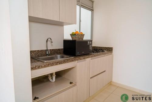 een keuken met een wastafel en een magnetron bij Apartamentos Sierra Verde Living in Apartadó