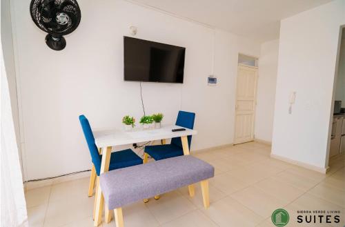 Apartamentos Sierra Verde Living في أبارتادو: غرفة مع طاولة وكراسي وتلفزيون