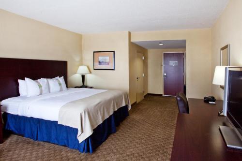a hotel room with a large bed and a tv at Holiday Inn Augusta West I-20 by IHG in Augusta