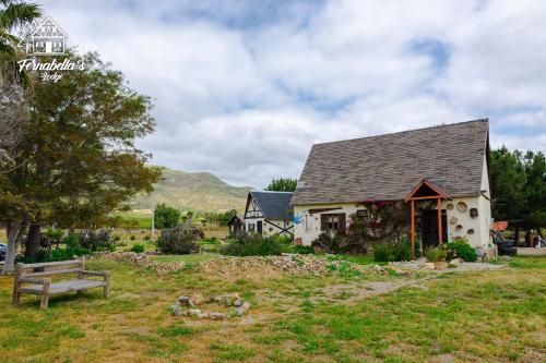 a house with a bench in a yard at Fernabella's Lodge in Valle de Guadalupe