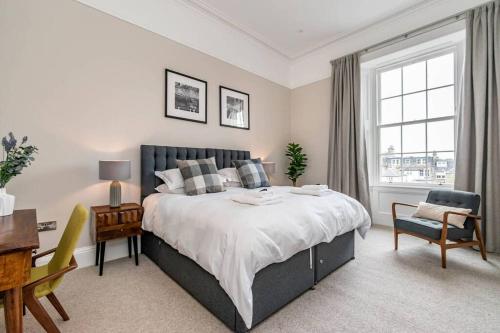 a bedroom with a large bed and a desk and a chair at Double Green House, Playfair Terrace in St. Andrews