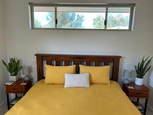 a bedroom with a yellow bed with two night stands at Serenity in Style in Kalbarri
