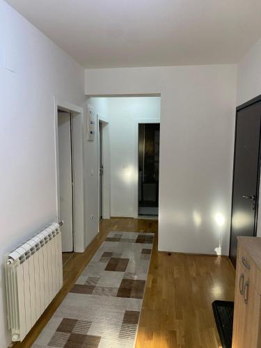 an empty living room with white walls and wooden floors at The Grand Residence in Novi Pazar