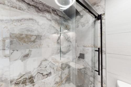 a bathroom with a shower with a marble wall at White Marlin 202A in Ocean City