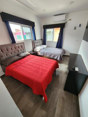 Cunduacánにあるhabitaciones disponibles con baño privado zona centroのベッドルーム1室(ベッド2台、赤毛布付)