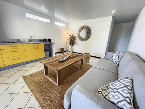 a living room with a couch and a table at JARDIN SUR MER in Terre-de-Haut