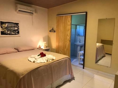 a bedroom with a bed with a flower on it at Pousada Canto do Boldró in Fernando de Noronha