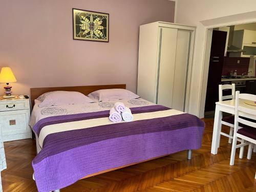 een slaapkamer met een bed met twee slippers erop bij Holiday apartments Duba Peljeska, Peljesac - 10231 in Trpanj