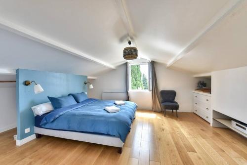 a bedroom with a blue bed and a chair at Villa vue mer Cannes in Mougins