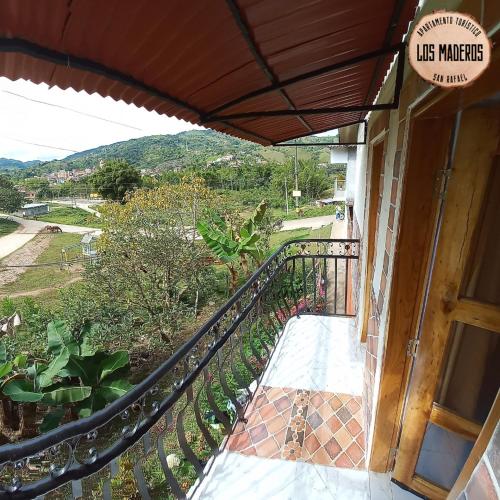 a balcony of a house with a sign that reads like market at Los Maderos San Rafael Antioquia Apartamento Turístico in San Rafael
