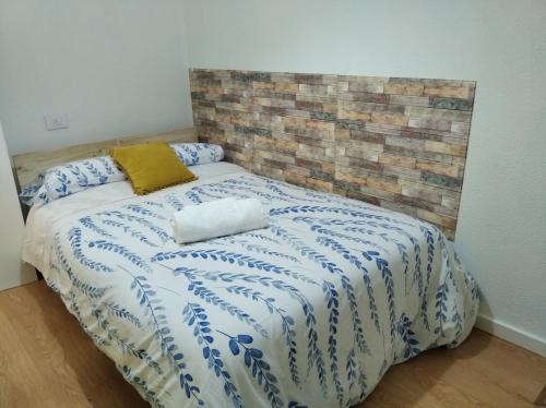 sypialnia z łóżkiem z niebiesko-białą kołdrą w obiekcie acogedor, con garaje, céntrico. w mieście Vigo