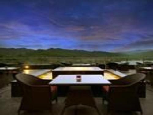 a table and chairs in a room with a view at Golden Tulip Chandigarh, Panchkula in Chandīgarh